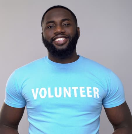 smiling African-American volunteer in blue t-shirt looking at camera